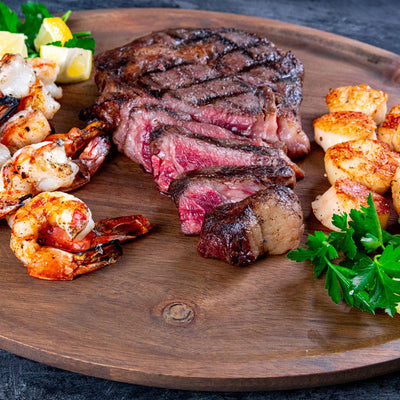 Ribeye Steak Shrimp Scallops on Cutting Board